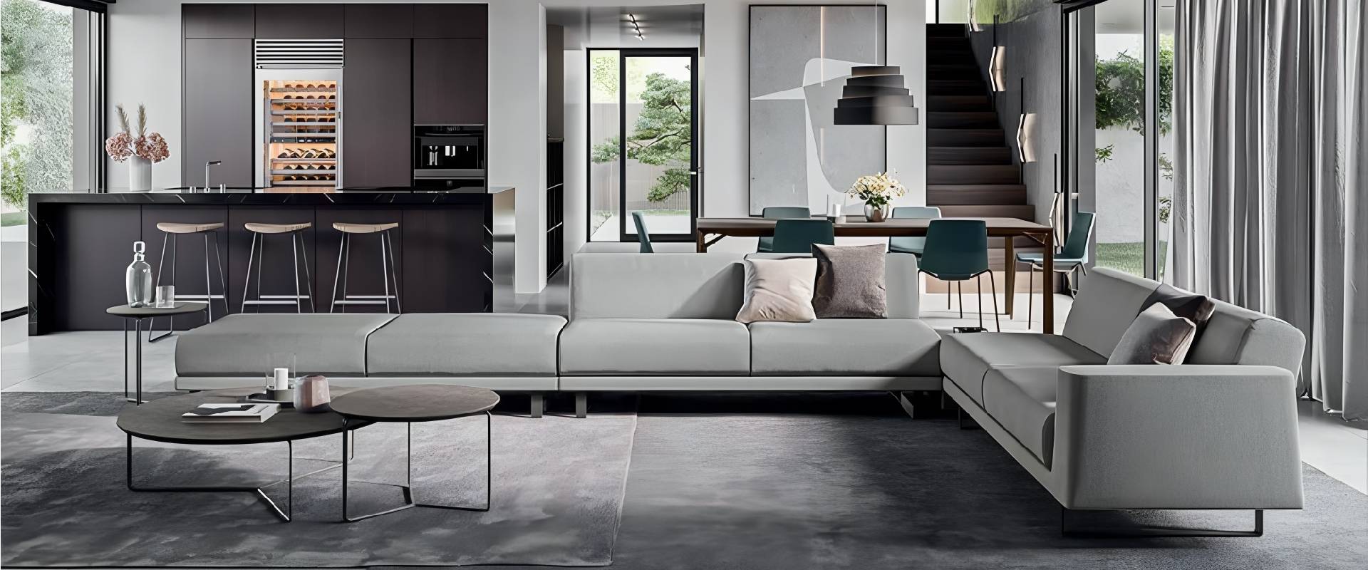 Modern open-concept living room and kitchen featuring a light grey sectional sofa, black kitchen island, dining area, floor-to-ceiling windows, and minimalist contemporary interior design.